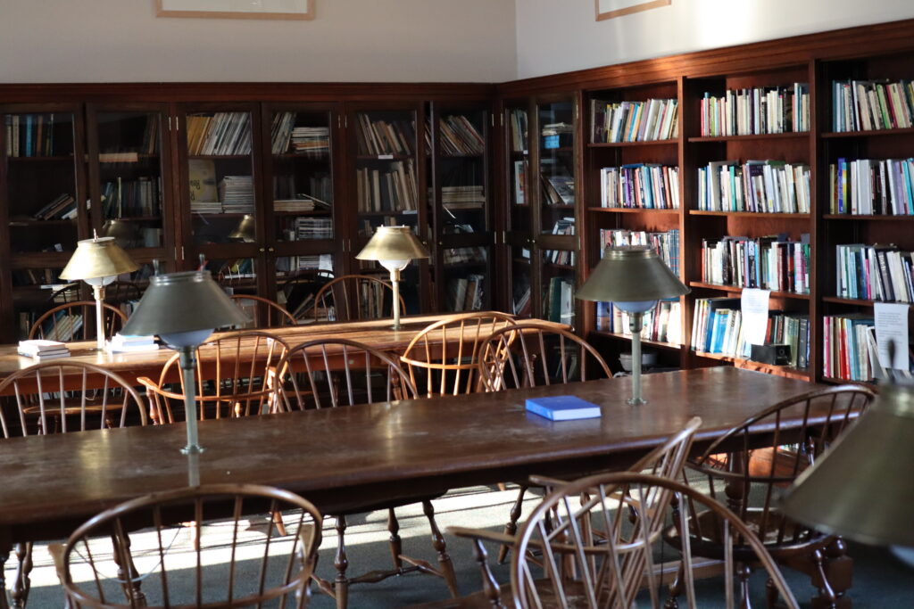 Photo of a study room in Farmer Hall with bookshelves and long tables with chairs.