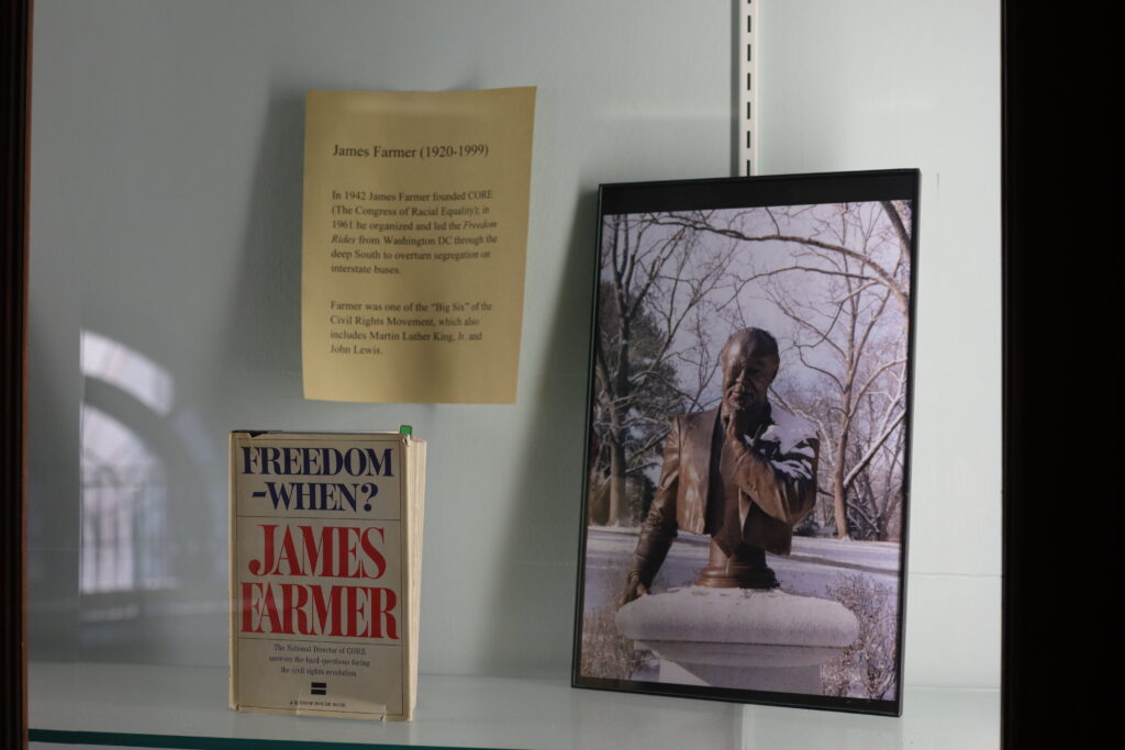 Photo of a display case with photo of Farmer bust and a copy of one of Farmer's books.